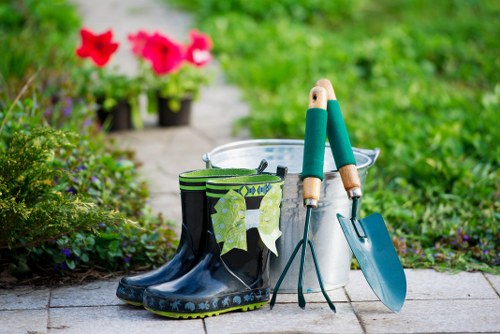 Gardener trimming a hedge with professional tools in a Pinner garden